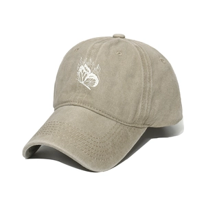 Detail of washed khaki baseball cap featuring white butterfly flame print and stitch brim