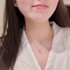 Gros plan d'un modèle portant des colliers superposés en or rose avec des gemmes marquises bleues