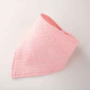 Détail d'un bavoir bébé rose en gaze de coton avec tissu respirant et bouton pression