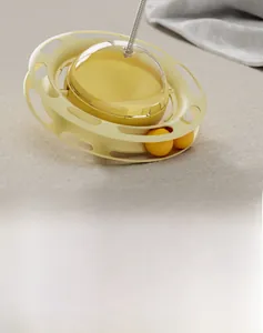 Top view of yellow 4-in-1 cat turntable toy with track balls and spring wand on grey fabric
