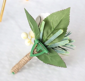 Detail view of handmade wedding boutonniere featuring white flower and pin attachment