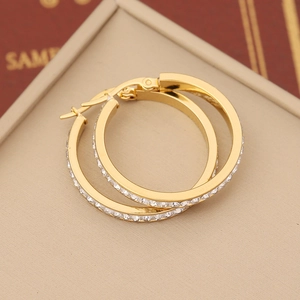 Elegant gold-plated heart hoop earrings with sparkling pave-set zircons on beige background
