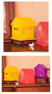 Detailed view of translucent house-shaped candle holders with star and heart cutouts