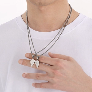 Silver heart pendant puzzle necklace in polished steel worn on a white t-shirt