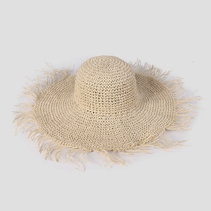 Detail of wide brim straw hat with natural frayed edges for summer sun protection