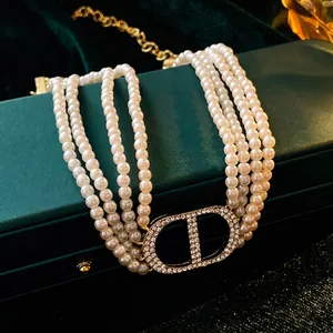 Elegant multi-layer pearl necklace with sparkling rhinestone CD letter pendant on gold chain