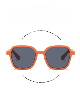 Detail view of lightweight and flexible orange square frame kids sunglasses with dark lenses