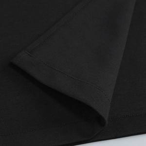 Detailed close-up of double-needle stitching and knit texture on black fabric hemline