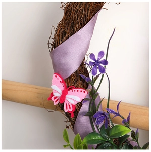 Detail of a Christmas wreath with lavender ribbons, felt butterflies, and faux flowers