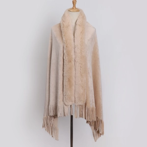 Detail of beige faux fur collar and fringe tassels on a thick flannel winter shawl
