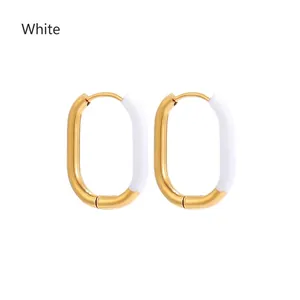 Detailed macro view of gold-plated U-shaped earrings with elegant white enamel inlay
