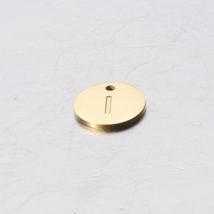 Macro detail of golden stainless steel 12mm round charm with engraved letter I