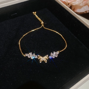 Detailed view of 18k gold plated butterfly bracelet with sparkling zircon on black velvet