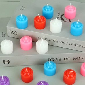 Macro shot of colorful cylindrical tea lights in red, blue, and white on a book