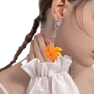 Boucles d'oreilles feuille d'érable en résine orange et tiges en argent sur modèle
