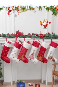 Set mit 6 Weihnachtsstrümpfen aus Samt mit Pailletten an einem festlichen Kamin