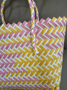 Detail of hand-woven tote bag with yellow, pink and white stripes in a zigzag pattern