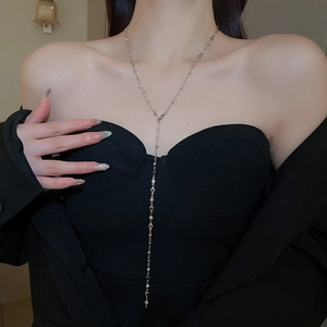Detail of elegant Y-shaped long tassel necklace with rhinestone hearts on model