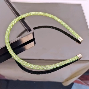 Macro detail of slim light green rhinestone headband with dense multi-faceted crystals