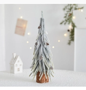 Close-up of a mini snowy pine Christmas tree with natural pinecones and a wooden base