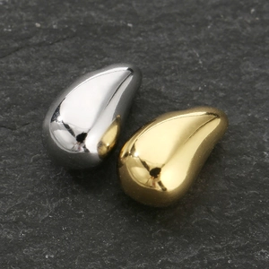 Macro shot of gold and silver teardrop pendants on a black textured stone background