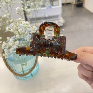 Detail of amber tortoiseshell bow hair claw clip made of polished acrylic acetate