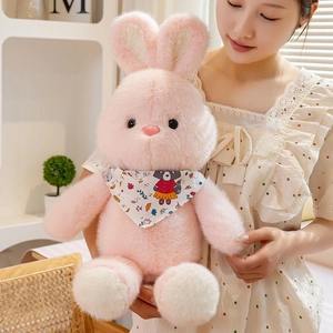 Soft pink plush rabbit doll with white scarf held by a model in a warm home setting