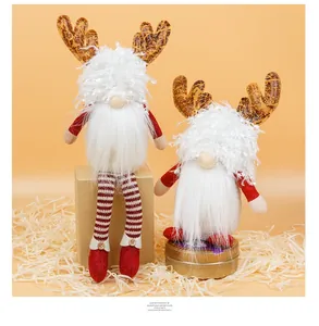 Detail of Christmas gnomes with reindeer antlers and red plush hats in festive setting