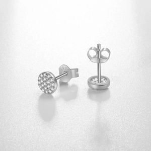 Detail of S925 sterling silver stud earrings with pavé cubic zirconia on white leather