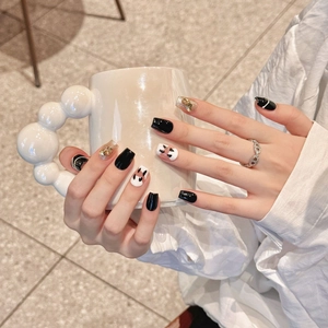Handmade black and white press-on nails featuring cat patterns and gold foil flakes