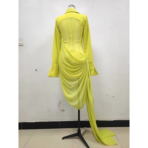 Detailed back view of neon yellow corset dress with long train and draped mesh detailing