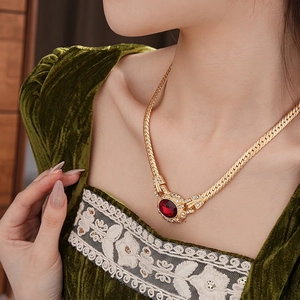 Vintage gold snake chain necklace with an oval red gemstone and crystal halo