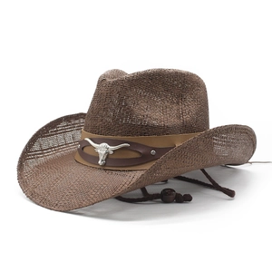 Detail of a brown woven cowboy hat with bull head silver emblem and leather strap