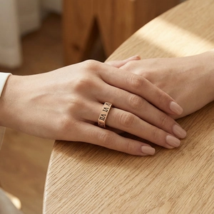 Détail d'une bague en acier inoxydable rose doré avec chiffres romains ajourés