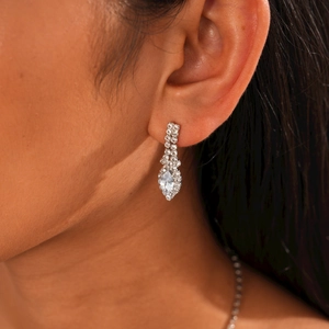 Close-up of elegant silver drop earrings with marquise-cut zircon stones on a model