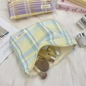 Detail of colorful plaid makeup bag showing zipper opening and spacious cotton interior