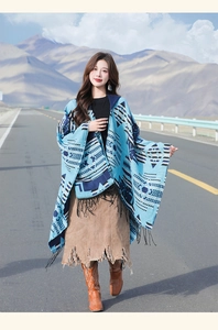 Detail of blue geometric ethnic shawl with fringes worn by a model in scenic mountains