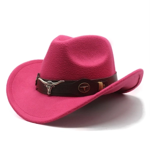 Détail macro d'un chapeau de cowboy rose avec ruban brun et emblème de tête de taureau