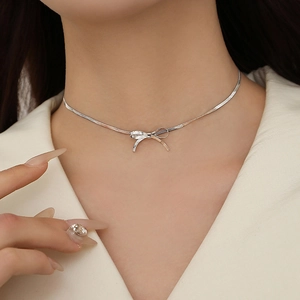 Elegante choker con ciondolo a fiocco argento e catena a serpente su una modella