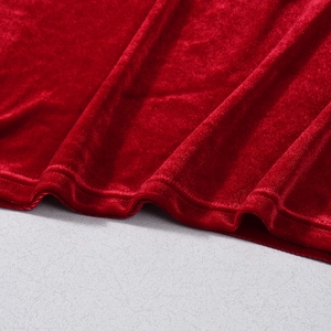 Detailed macro view of red velvet fabric texture with precise stitching and glossy finish