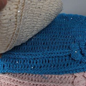 Dettaglio ravvicinato di cappelli in maglia con fiori scintillanti multicolore