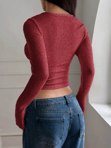 Close-up of red ribbed knit long sleeve crop top showcasing texture and slim fit design