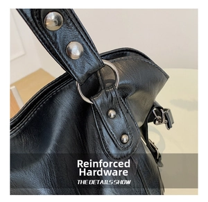 Detail of reinforced leather strap with silver metal ring and rivets on black tote bag