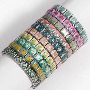 Detail view of Italian charm bracelet links featuring colorful floral motifs and steel base