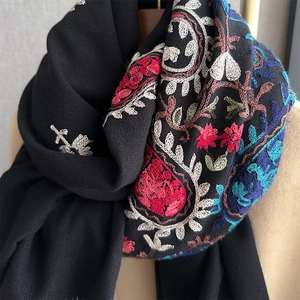 Gros plan sur la broderie cachemire colorée et le tissu doux d'un châle noir