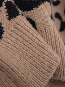 Macro shot of V-neck leopard knit sweater showing ribbed cuff texture and fluffy fabric