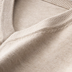 Makro-Detail von V-Ausschnitt-Rippstrick und weicher Textur am Wollmischpullover