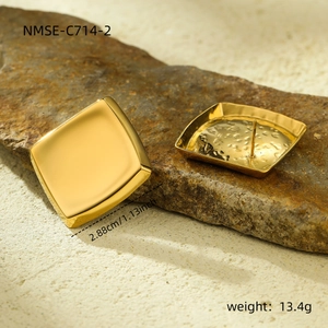 Detailed macro view of 18K gold-plated geometric square earrings on a dark stone background