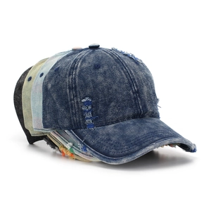 Stack of distressed denim baseball caps showing ripped details and varied vintage washes