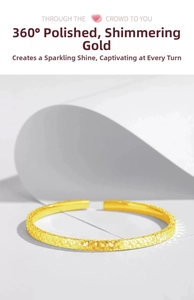 Detail of gold open bracelet with multifaceted shimmering scale texture and polished finish